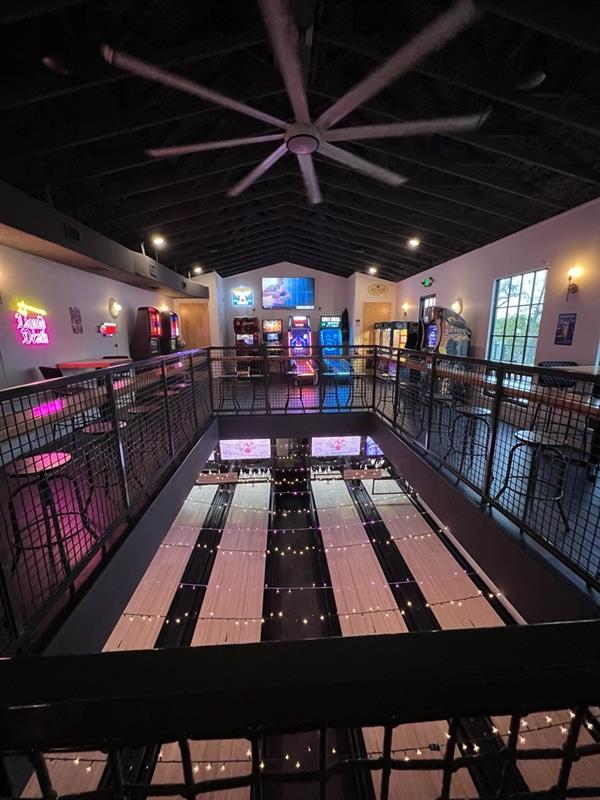 Indoor bowling alley with balcony covered in string lights