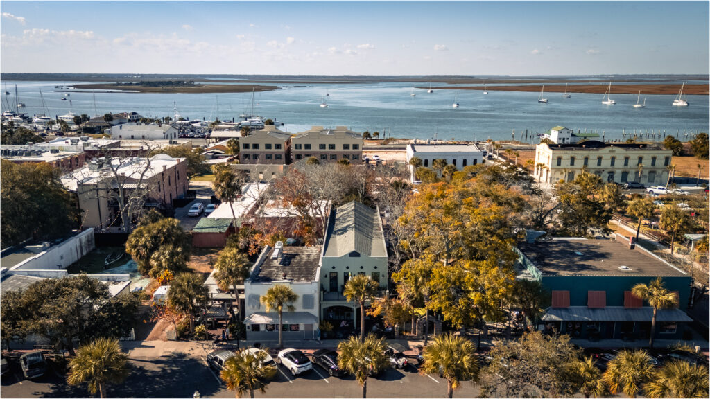 Aerial view of a building surrounded by autumn trees and a body of water